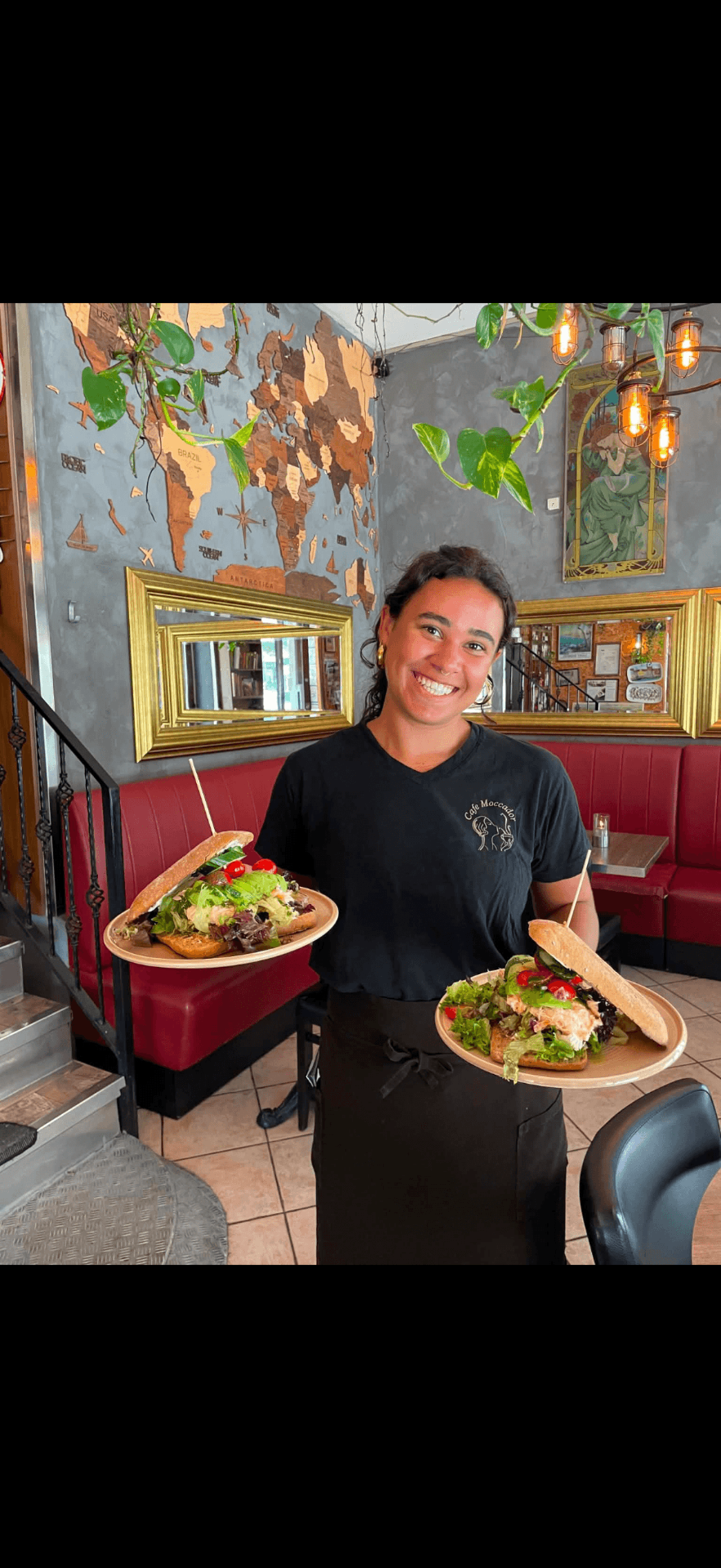 Smilende tjener bag baren hos Café Moccador – café på Falkoner Allé, Frederiksberg